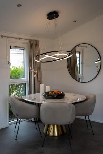 a dining room with a table and a mirror at Qué Vida, Boutique Chalet aan Zee en Meer in Scharendijke