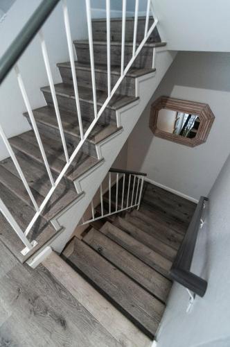 a staircase with white railings and wood floors at 50 M to Sand LGB 2 King Suites in Long Beach