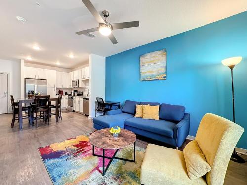 a living room with a blue couch and a table at Luxury Apartments Near Disney in Orlando