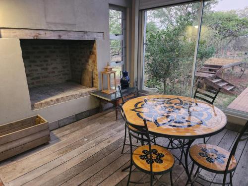 a room with a table and chairs and a fireplace at Verloren Lodge in Modimolle