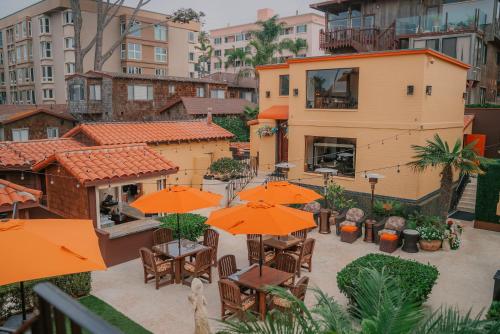 an outdoor patio with tables and orange umbrellas at Pantai Inn in San Diego