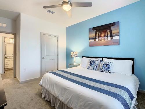 a bedroom with a large bed with a blue wall at Luxury Apartments Near Disney in Orlando