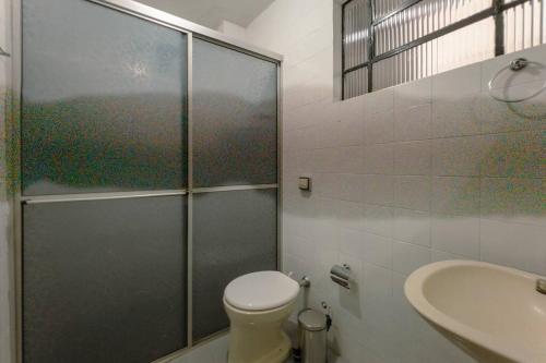 a bathroom with a shower and a toilet and a sink at Apartamento Centro até 6 - EV01 in Maringá