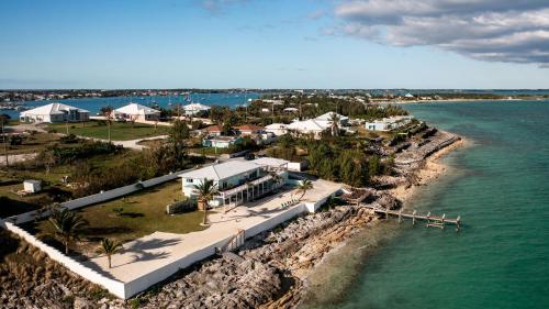 an aerial view of a house on the shore of the water at Private Oceanfront, beach, dock and Hottub - The Perky Pelican in Marsh Harbour