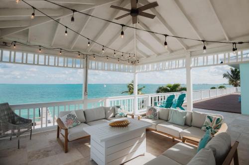 a living room with a view of the ocean at Private Oceanfront, beach, dock and Hottub - The Perky Pelican in Marsh Harbour