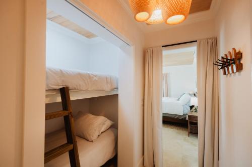 a bedroom with a bunk bed and a mirror at Private Oceanfront, beach, dock and Hottub - The Perky Pelican in Marsh Harbour