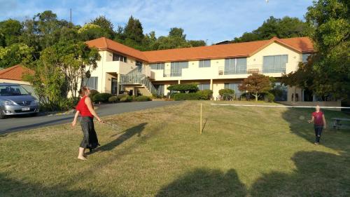 two people playing with a kite in the yard of a house at Abelia Motor Lodge in Nelson