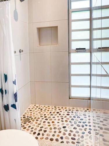 a bathroom with a shower and a tile floor at Casa Bella Vista in Puerto Escondido