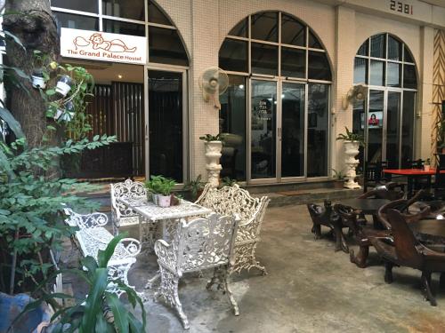 eine Terrasse mit Stühlen und einem Tisch vor einem Gebäude in der Unterkunft The Grand Palace Hostel in Bangkok