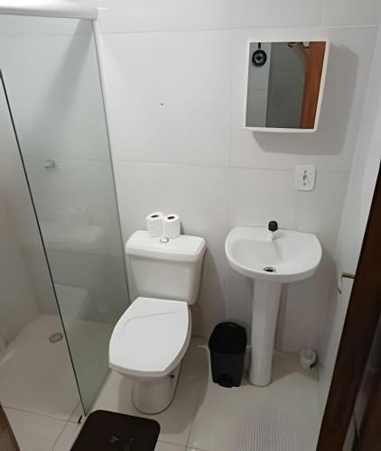 a white bathroom with a toilet and a sink at otimo apart 2 quartos no recreio dos bandeirantes in Rio de Janeiro