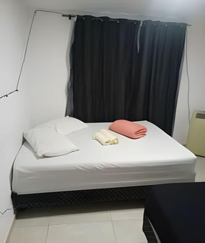 a bed in a room with a black curtain at otimo apart 2 quartos no recreio dos bandeirantes in Rio de Janeiro
