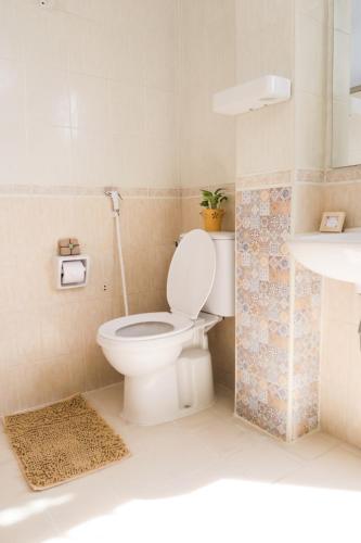 a bathroom with a toilet and a sink at The Grand Palace Hotel in Bangkok