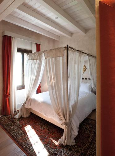 a bedroom with two beds with white curtains at La Barchessa di Villa Pisani in Lonigo