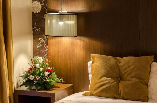 a bedroom with a bed with a flower arrangement on a table at Hotel Duas Nações in Lisbon