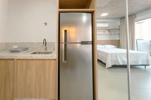 a kitchen with a refrigerator in a room with a bed at Moderno e Belíssimo - CA1006 in Maringá