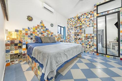 a bedroom with a bed in a room with lots of tiles at Casa Amigos in Isla Mujeres