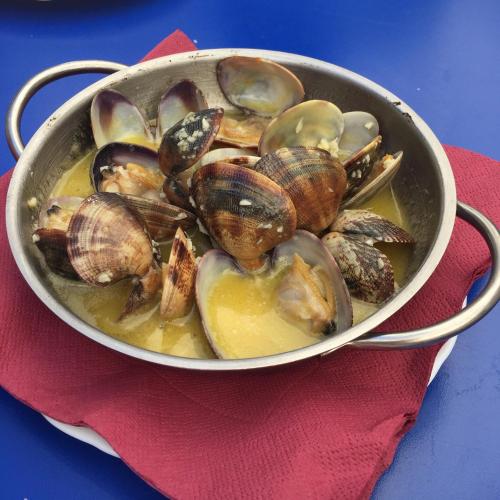 a pot filled with clams on a red napkin at Apartamento Cortelazor in Huelva