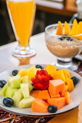 a plate of fruit on a table with a drink at Stardome Spiritual Experience in Ollantaytambo
