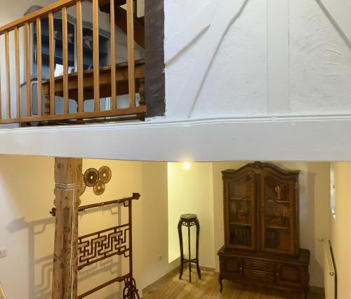 a room with a staircase and a wooden cabinet at Charmante maison de 140m2 au bord de la rivière au coeur de Wissembourg in Wissembourg