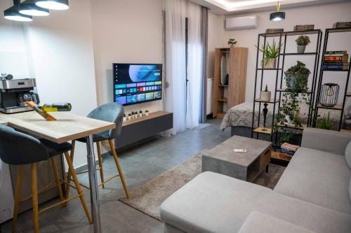 a living room with a couch and a table and a tv at Nick's Crib in Síndos