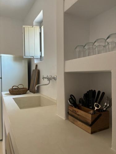 a kitchen with a sink and a counter with utensils at Saliagos villas complex with private pools in Antiparos