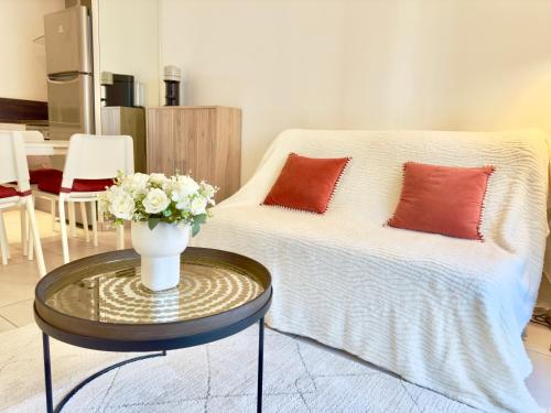 une chambre avec un lit et une table avec un vase de fleurs dans l'établissement Superbe appartement avec Terrasse 1mn des plages de la Croisette, à Cannes