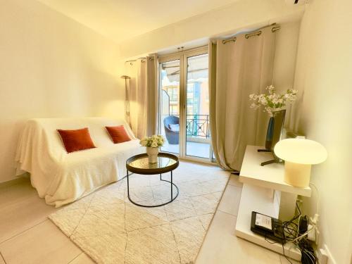 - une chambre avec un lit, une table et un balcon dans l'établissement Superbe appartement avec Terrasse 1mn des plages de la Croisette, à Cannes