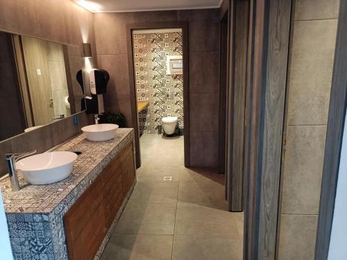 Un baño con dos lavabos sobre una encimera y un espejo. en Despina Apts by Estia, en Gouves