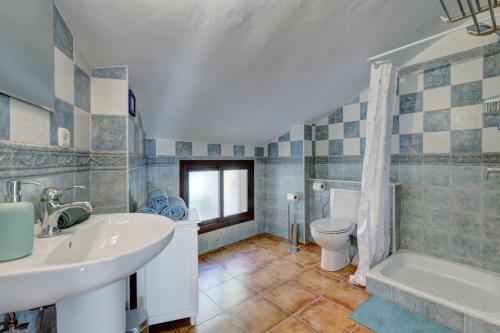 a bathroom with a sink and a toilet and a tub at Apartament Ewa z widokiem Casares in Casares