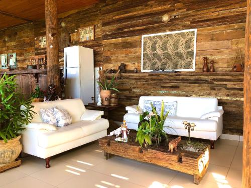 a living room with two couches and a coffee table at Bangalô Maria Vista Mar, Luxo em Trancoso in Porto Seguro