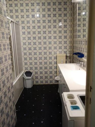 La salle de bains est pourvue d'un lavabo blanc et de carrelage noir. dans l'établissement Résidence Majestic I - APPARTEMENT ALPE D'HUEZ QUARTIER VIEL ALPE MAE-2021, à Huez