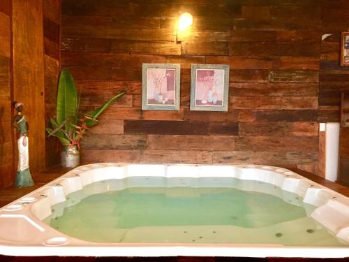 a jacuzzi tub in a room with two pictures at Bangalô Maria Vista Mar, Luxo em Trancoso in Porto Seguro