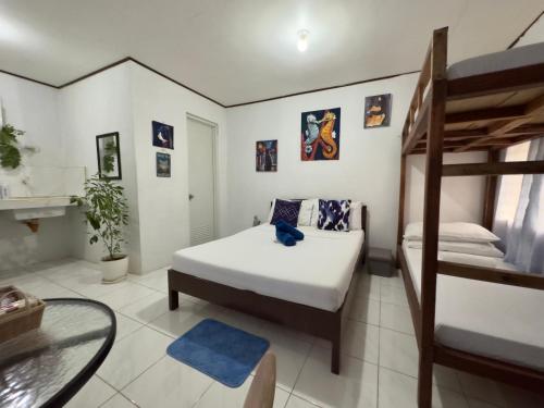 a bedroom with two beds and a glass table at Catio Apartments in Panglao