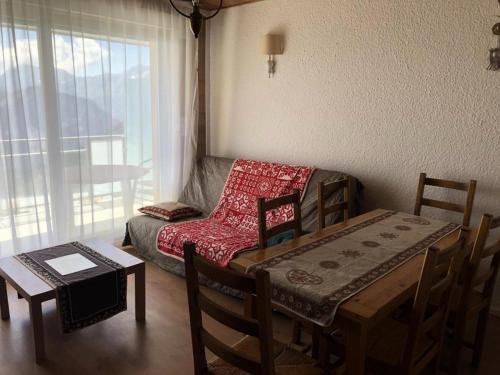 - un salon avec une table, une chaise et un canapé dans l'établissement Résidence Majestic Ii - APPARTEMENT ALPE D'HUEZ QUARTIER VIEL ALPE MAE-2031, à Huez