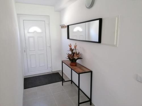 a hallway with a mirror and a table with a plant on it at Serra e Mar in Alcaria