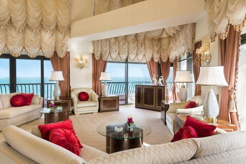 a living room with couches and a view of the ocean at Sheraton Grand Doha Resort & Convention Hotel in Doha