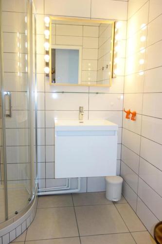une salle de bain avec un lavabo, une douche et un miroir dans l'établissement Résidence Helios - APPARTEMENT ALPE D'HUEZ ROUTE DU COULET CENTRE STATION MAE-2101, à Huez