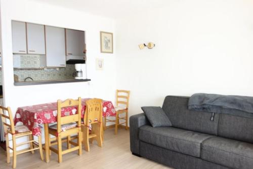 un salon avec un canapé, une table et des chaises dans l'établissement Résidence Majestic Ii - APPARTEMENT ALPE D'HUEZ QUARTIER VIEL ALPE MAE-2091, à Huez