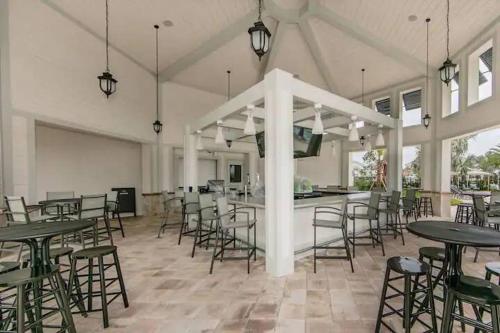 a large room with tables and chairs and a flat screen tv at Waterpark Disney wPoolLakeView Storey Lake in Kissimmee