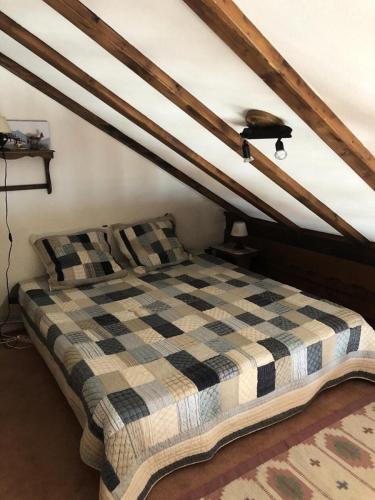 - une chambre mansardée avec un lit à damiers dans l'établissement Résidence Musardiere - APPARTEMENT ALPE D'HUEZ CENTRE STATION MAE-2111, à Huez