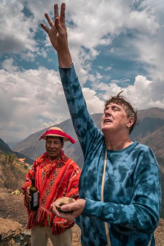 two men standing on top of a mountain with their hand in the air at Stardome Spiritual Experience in Ollantaytambo