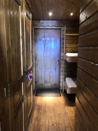 - une porte en bois dans une chambre avec couloir dans l'établissement Résidence Musardiere - APPARTEMENT ALPE D'HUEZ CENTRE STATION MAE-2131, à Huez
