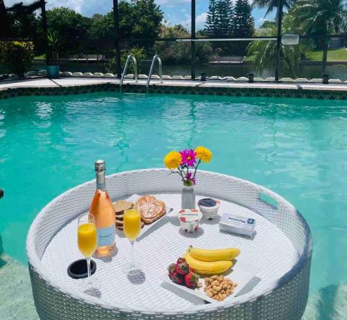 a table with food and drinks in a swimming pool at Hidden Secret Waterfront Retreat in Cape Coral