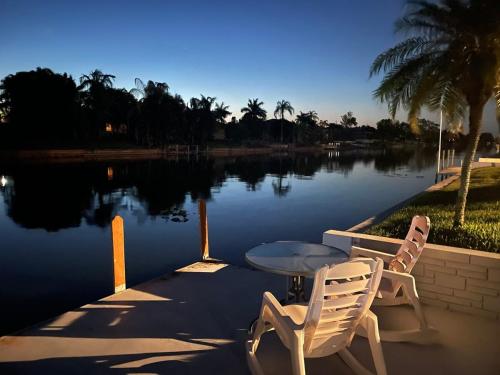 a table and two chairs sitting next to a lake at Hidden Secret Waterfront Retreat in Cape Coral