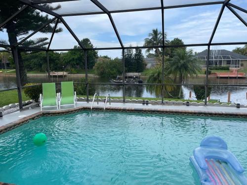 a pool with chairs and a ball in the water at Hidden Secret Waterfront Retreat in Cape Coral