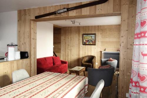Cette chambre est dotée de murs en bois, d'une table et de chaises. dans l'établissement Résidence Kandahar - APPARTEMENT ALPE D'HUEZ AVENUE DU RIF NEL MAE-2201, à Huez