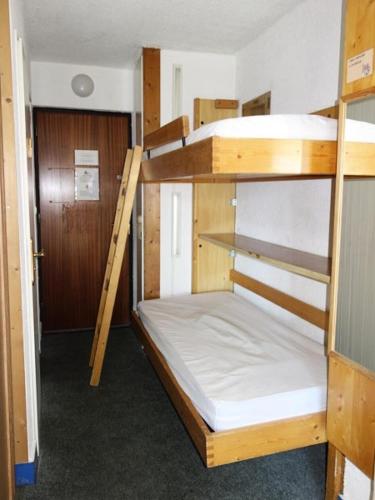 Cette chambre comprend 2 lits superposés et une porte. dans l'établissement Résidence Menandiere - APPARTEMENT ALPE D'HUEZ CENTRE STATION MAE-2241, à Huez