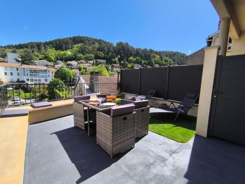 d'une terrasse avec une table sur un balcon. dans l'établissement Charmant meublé de tourisme 4 étoiles, à Vals-les-Bains