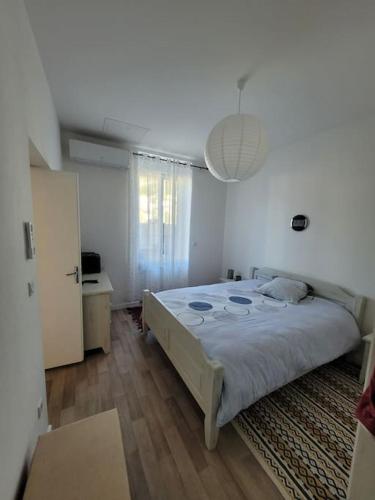 une chambre avec un grand lit dans une pièce blanche dans l'établissement Charmant meublé de tourisme 4 étoiles, à Vals-les-Bains