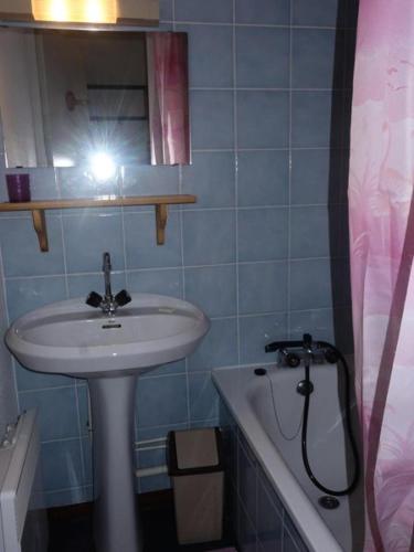 La salle de bains est pourvue d'un lavabo, d'un miroir et d'une baignoire. dans l'établissement Résidence Soleil D'huez - APPARTEMENT ALPE D'HUEZ QUARTIER DE L'ECLOSE MAE-2281, à Huez